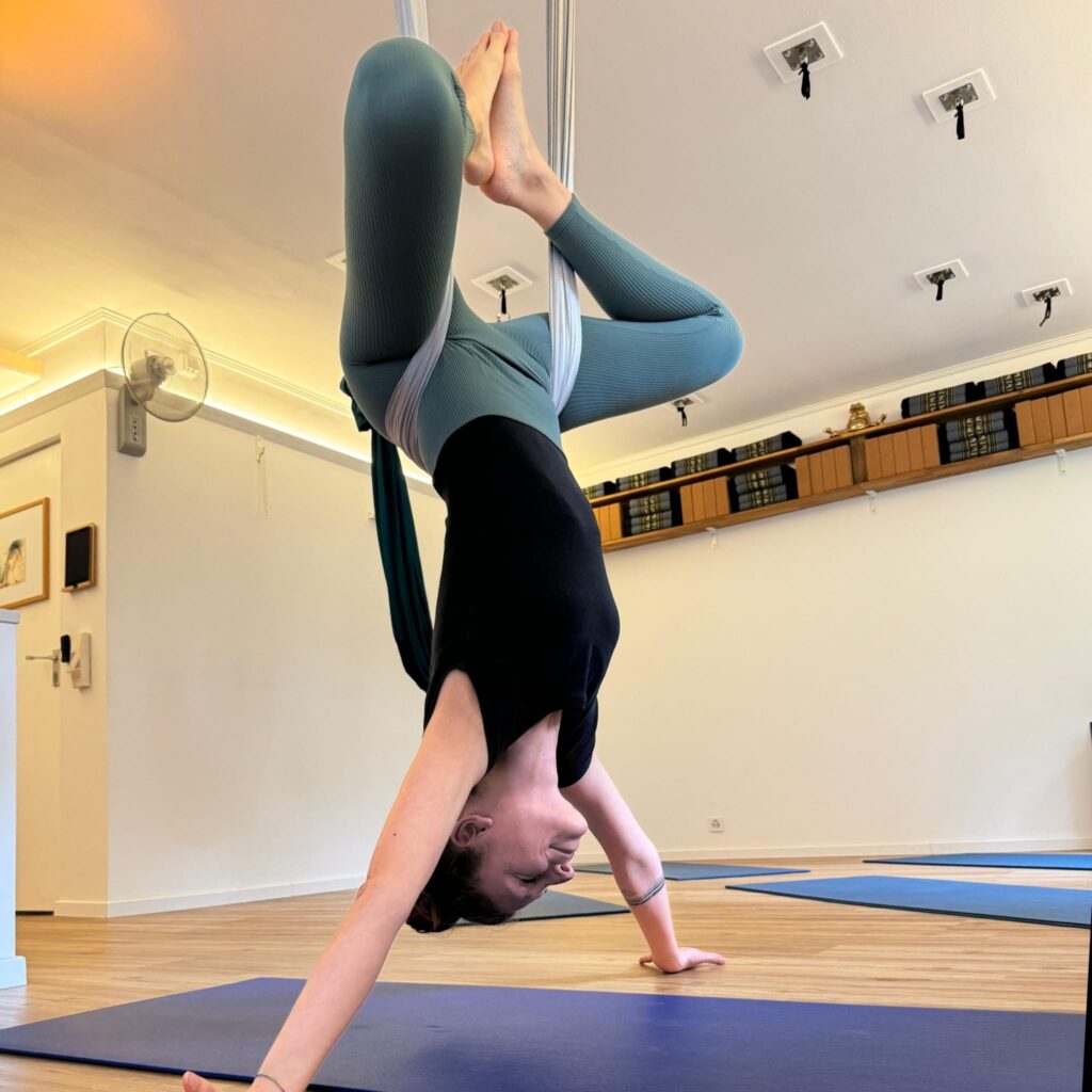 Aerial yogi hanging upside down in inversion